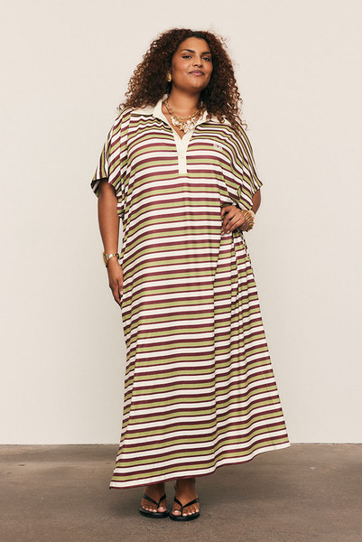 The Maggie T-Shirt Dress redefines relaxed polish. Crafted from silky striped polyester, it features a contrast collar, embroidered logo, and fluid drape that moves with ease. Its mid-length silhouette and effortless comfort make it perfect for day-to-night styling. Casual, confident, and crafted for women who favour style with soul.