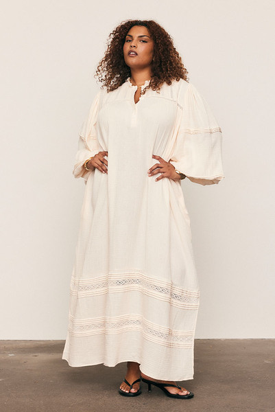 Light, effortless and full of movement, the Kinney Billow Dress is crafted from pure double cotton with delicate lace and pintuck detailing. Featuring a soft ruffle neckline, voluminous sleeves and a flowing silhouette, it drapes beautifully with every step. A timeless expression of bohemian ease. Breathable, versatile and endlessly flattering on every size.