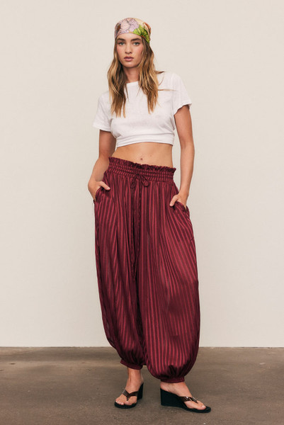 These lightweight lurex-striped pants shimmer in magenta, falling in a relaxed, ankle-length silhouette. Smocked waist, drawcord, and cuffed ankles offer effortless comfort, while side pockets add practical ease—perfect for day-to-night dressing with a confident, modern edge.