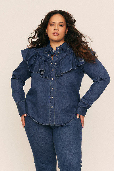 A timeless staple with a romantic edge, the Ruffle Denim Shirt redefines denim shirting with soft structure and thoughtful detail. Crafted from premium mid-weight cotton denim, it features a circular frill tracing the front and back yoke—bringing movement and femininity to a classic silhouette.