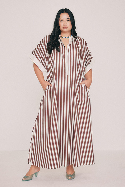 Cut from crisp cotton poplin, this brown striped maxi dress is oversized with wide grown-on sleeves. A mandarin collar buttons to the neckline or opens to the chest, while side splits and side pockets lend ease. Nothing is fitted anywhere, which is rather the point and makes it a continued best seller. Intended to be oversized. Designed from a 6 to a 22.