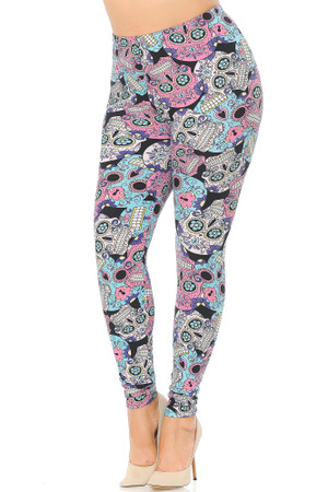 Angled front view image of Buttery Smooth Pastel Sugar Skull Plus Size Leggings featuring a colorful soft toned pink blue and white all over intricately decorated sugar skull design with floral touches against a black background that peeks through a little.