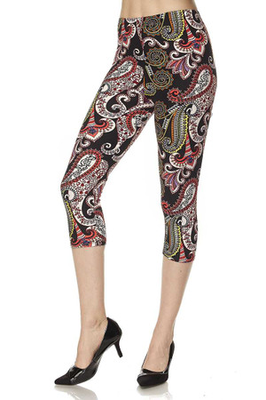 Angled front view of our Buttery Smooth Raspberry Paisley Capris featuring a predominantly white and burgundy paisley design with decorative accents, against a black background.