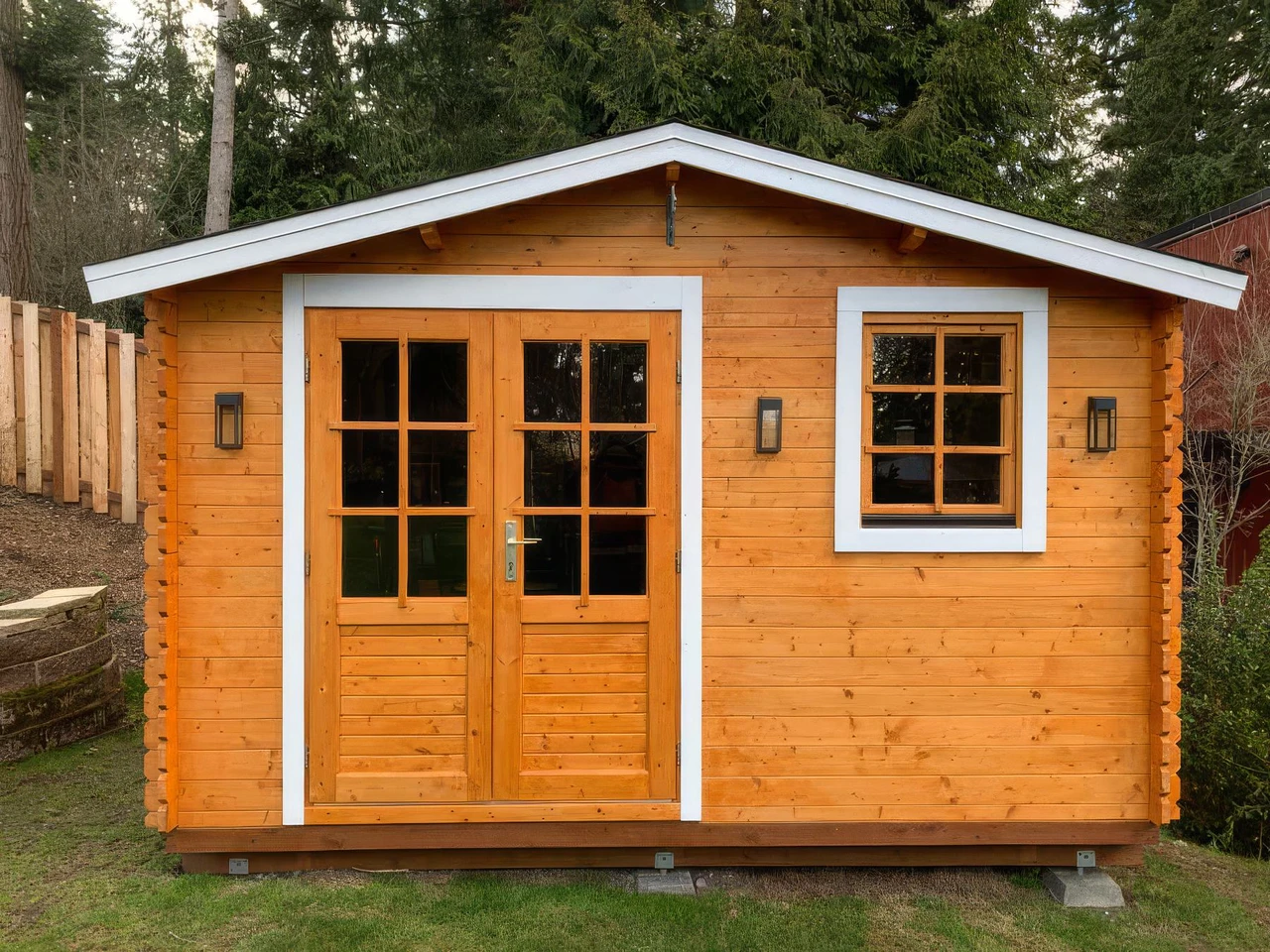Optima 12 × 12 classic shed in natural cedar with a white-trimmed gable, glazed double doors and a side window