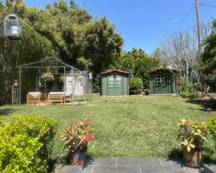 A view of the backyard with two beautiful home office sheds in the background