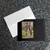 Black wallet photo card lies on a granite countertop with a white mailing envelope.