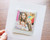 Two tabs hold your Instax Square print in place Two tabs hold your Instax Square print in place