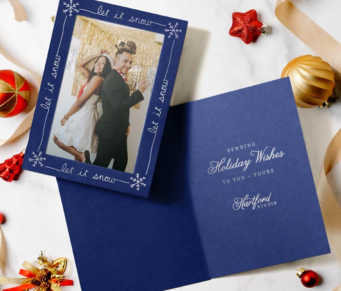 Blue photo insert card with silver foil let it snow greeting on the frame.