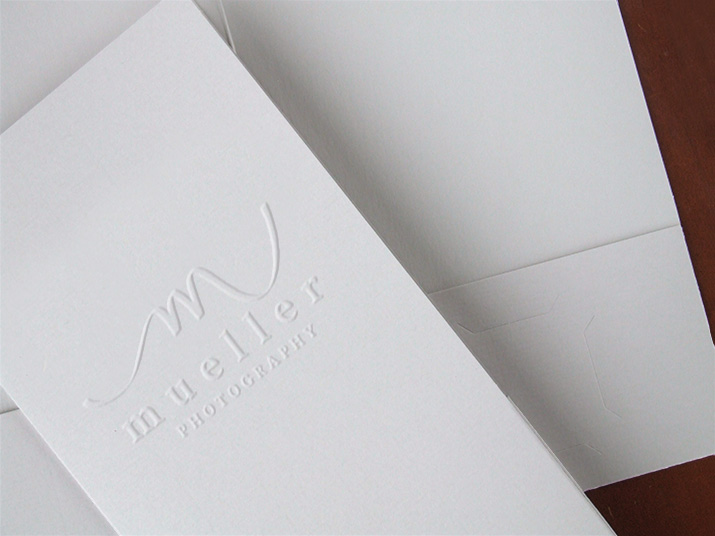 White pocket folder with blind embossed logo on the front cover