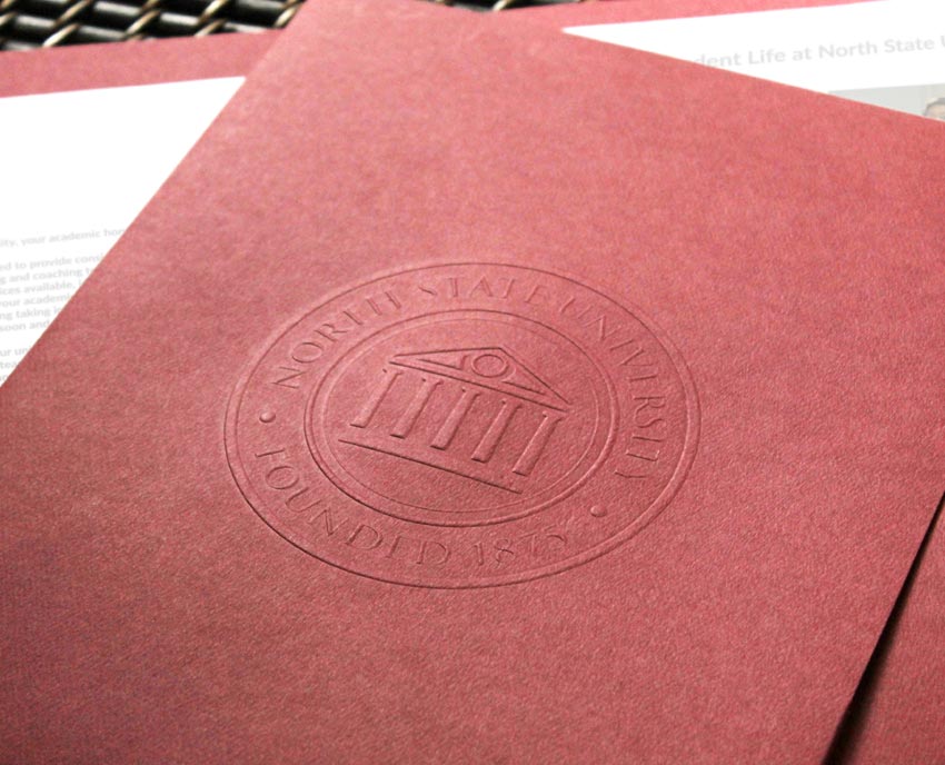 Burgundy pocket folder with embossed university emblem