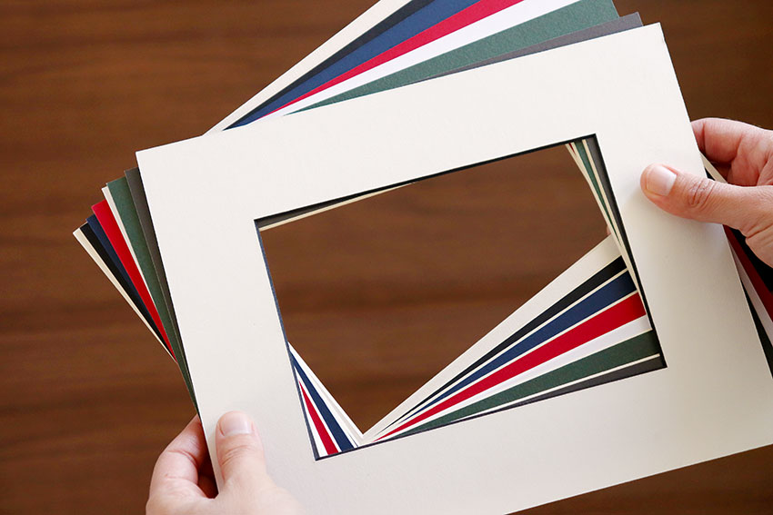 Someone holds a sampling of photo mats in many colors