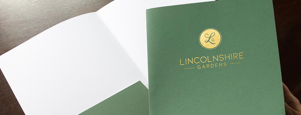 Recycled green pocket folder with gold foil garden center logo stamped on the front cover.