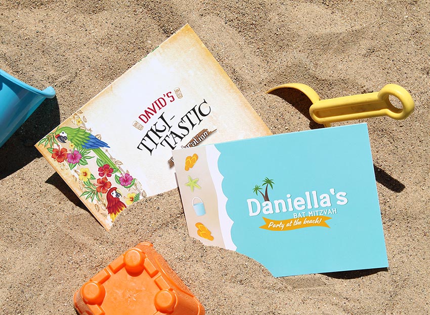 A tropical and beach-themed photo folder in sand with beach toys