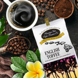 Bag of English Toffee coffee next to coffee cup, beans and flower