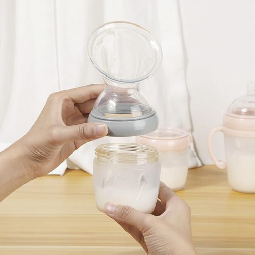 Haakaa Generation 3 Silicone Breast Pump being held with the top and bottle detached