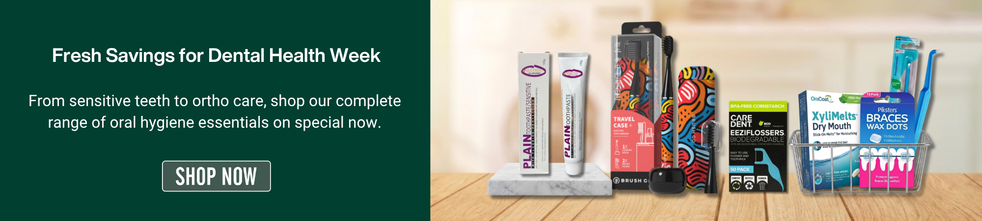 A promotional banner for Dental Health Week featuring the text 'Fresh Savings for Dental Health Week: From sensitive teeth to ortho care, shop our complete range of oral hygiene essentials on special now,' alongside a 'SHOP NOW' button. On the right, a curated selection of oral care products is displayed on a wooden surface in a blurred bathroom setting. The products include toothpaste, electric toothbrushes, flosser picks, dry mouth melts, and orthodontic wax dots.