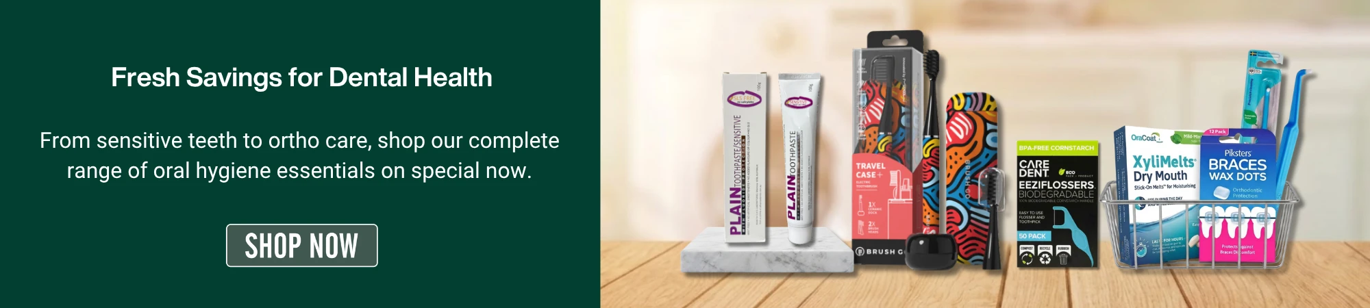 A promotional banner for Dental Health Week featuring the text 'Fresh Savings for Dental Health Week: From sensitive teeth to ortho care, shop our complete range of oral hygiene essentials on special now,' alongside a 'SHOP NOW' button. On the right, a curated selection of oral care products is displayed on a wooden surface in a blurred bathroom setting. The products include toothpaste, electric toothbrushes, flosser picks, dry mouth melts, and orthodontic wax dots.