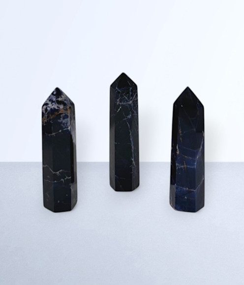 Sodalite - a variety of points in medium sizes, against a light blue background.