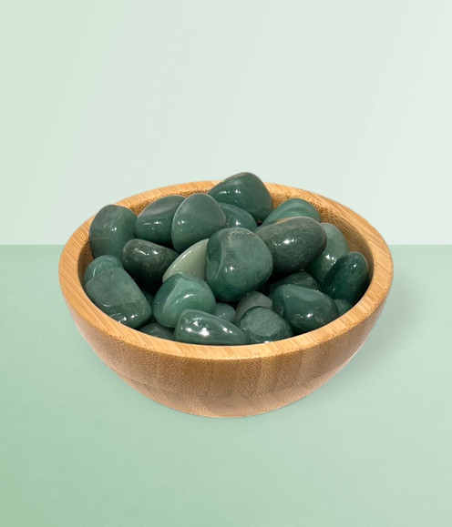 Aventurine - bowl of tumbled pieces, against a lime green background.