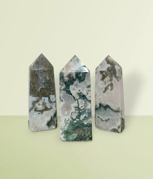 Moss Agate - a variety of points in extra-small-sized pieces against a lime green background.