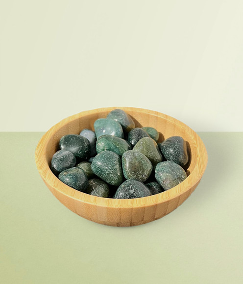Aventurine - bowl of tumbled pieces, against a lime background.