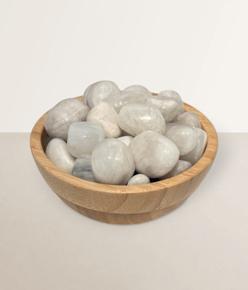 Moonstone - a bowl of assorted tumbled pieces, against a light cream coloured background.