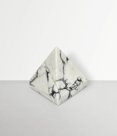 Howlite - a sample of a pyramid carving, in a small size, against a dark gray background. Howlite - a sample of a pyramid carving, in a small size, against a dark gray background.