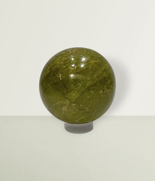 Green Opal Orb - solo piece #1, from the front, against a light lime coloured background. Green Opal Orb - solo piece #1, from the front, against a light lime coloured background.