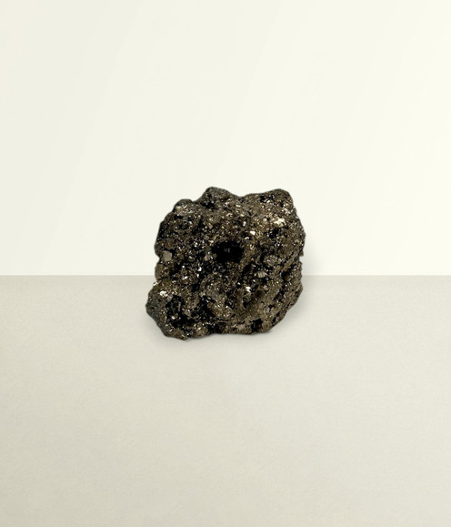 Pyrite Cluster - solo piece #1, from the front, against a light cream coloured background. Pyrite Cluster - solo piece #1, from the front, against a light cream coloured background.