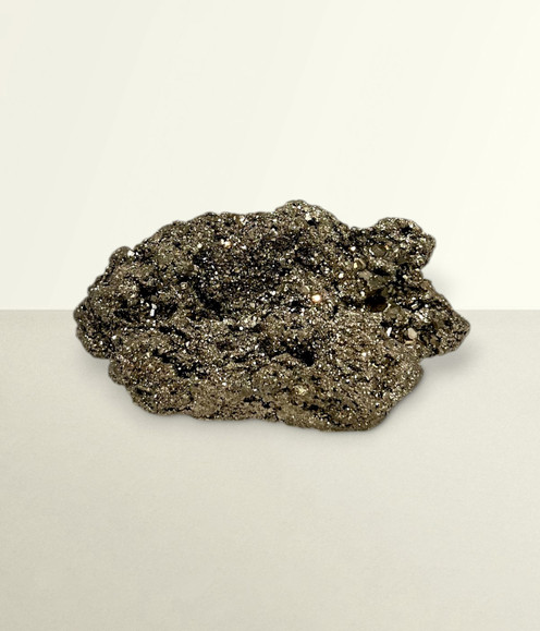 Pyrite Cluster - solo piece #2, from the front, against a light cream coloured background. Pyrite Cluster - solo piece #2, from the front, against a light cream coloured background.
