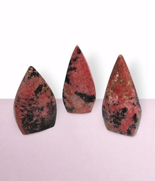 Rhodonite Pointed Freeforms - a variety of pieces in medium sizes, against a light pink background.