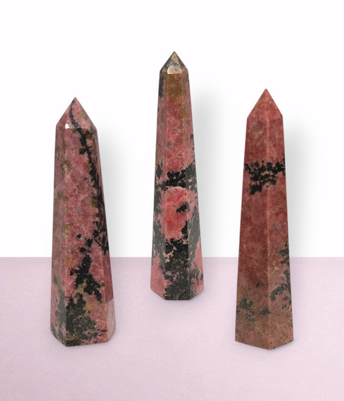 Rhodonite Points - a variety of pieces in medium & large sizes, against a light pink background. Rhodonite Points - a variety of pieces in medium & large sizes, against a light pink background.