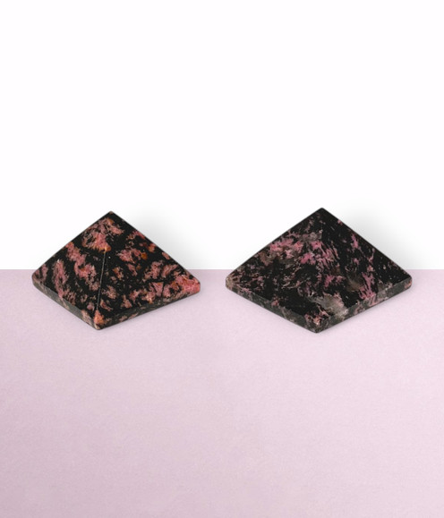 Rhodonite Pyramids - a variety of pieces in small sizes, against a light pink background. Rhodonite Pyramids - a variety of pieces in small sizes, against a light pink background.
