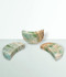 Caribbean Calcite Moons - a variety of pieces in a small size, against a cool blue-green coloured background.