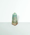 Caribbean Calcite Points - a sample of a small sized piece, at an angle, against a cool blue-green coloured background.