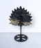 Sodalite Peacock Feather Carving - unique piece #1, held up on a black metal display stand, front-facing, against a light blue background.