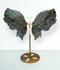 Labradorite Butterfly Wings Carving - unique piece #1, held up on a gold metal display stand, front-facing, against a light blue background. Labradorite Butterfly Wings Carving - unique piece #1, held up on a gold metal display stand, front-facing, against a light blue background.