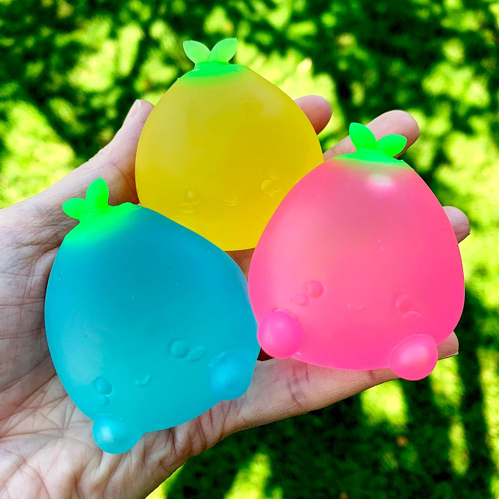 The Sugar Squisher Mini Fruits 2-Pack arranged in a playful setting, featuring the strawberry and pineapple squishy toys, highlighting their cute and collectible nature