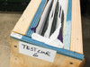 Yamashita Denso PXS-0855MP — end of wooden crate labeled 'TEST LINE 6' in marker, showing layered foam, glass, and textile packing materials inside the crate opening