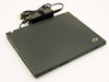 IBM ThinkPad T41 closed top lid view with IBM ThinkPad logo and AC adapter resting on top