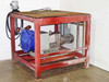 Left-rear three-quarter view of pump skid showing motor, gearbox, and platform frame