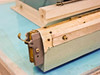 AIE AIE-605A1 close-up of left end of sealing bar showing heating element, PTFE tape, and end clamp hardware