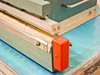 AIE AIE-605A1 close-up of right end of sealing bar with red end cap and tension adjustment hardware