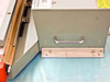 AIE AIE-605A1 side view showing carry handle, mounting foot, and blue work surface with yellow caution label