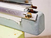 TEW TISF-452 opposite sealing jaw end showing surface scratches on bar and rust on fastener hardware