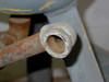 Detail of open-ended bottom drain pipe stub showing threaded interior with rust and corrosion