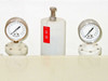 Two Helicoid PSI pressure gauges flanking a white polypropylene component on top of HDPE tank — close-up with red asset tag CU 02