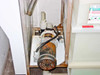 Iwaki Walchem MDH-400CV5 magnetic drive pump mounted in lower cabinet enclosure — heavily corroded exterior with chemical residue visible