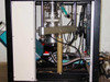 Interior frame view showing cryogenic chamber from below with turbo pump bellows, plumbing, wiring, and support structure
