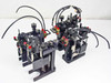 Two complete SMC NCRB1BW20-90S rotary actuator assemblies shown together with pneumatic tubing and red-cap fittings attached